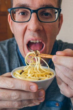 Spagetti ve cırcır böcekleri yiyen adam