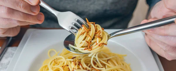 Rękach mężczyzna jedzenie spaghetti z robakami — Zdjęcie stockowe