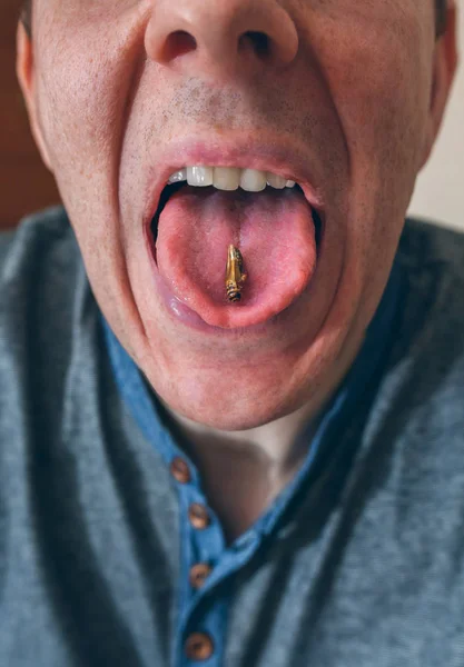 Man showing a cricket on his tongue — Stock Photo, Image