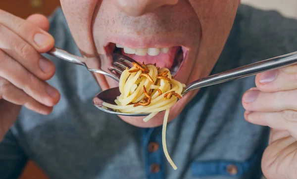 Uomo che mangia spaghetti con vermi — Foto Stock