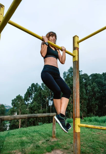 Atleta femenina haciendo ejercicios pull up — Foto de Stock