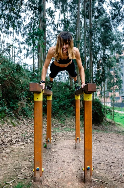 Atleta mujer entrenamiento en barras paralelas — Foto de Stock
