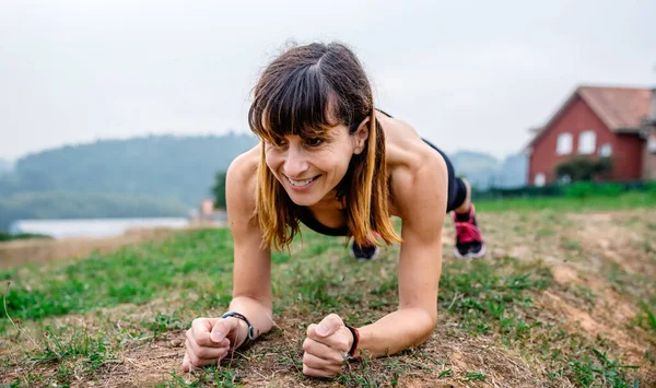 Entrenamiento de atleta femenina haciendo tablón — Foto de Stock