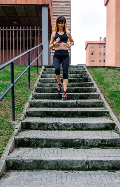 Női sportoló megy le a lépcsőn a szabadban — Stock Fotó
