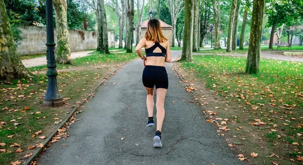 Atleta corriendo por un parque — Foto de Stock