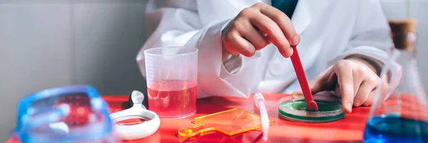 Jungenhände spielen Chemiker mit bunten Flüssigkeiten — Stockfoto