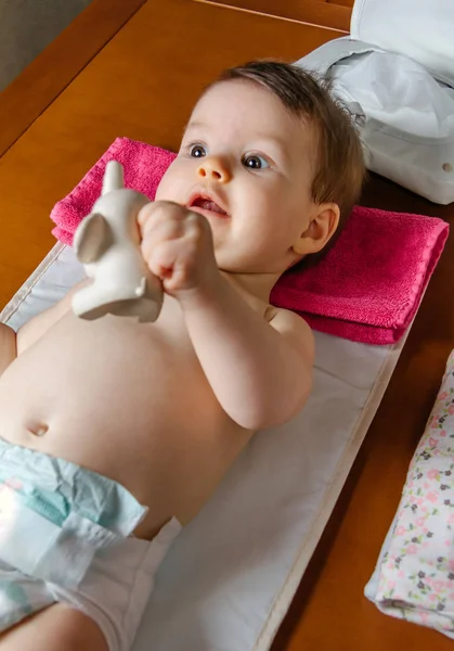 Baby liggend spelen met een rubber speelgoed — Stockfoto