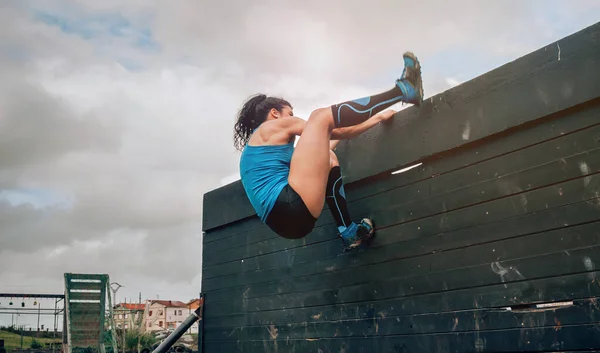 Participant in obstacle course climbing wall — Stock Photo, Image