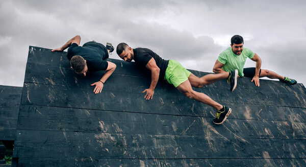 Participants in obstacle course climbing wall