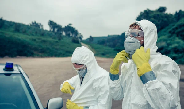 Twee jongeren die bacteriologische beschermingspakken aantrekken — Stockfoto