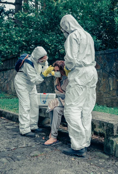 Artsen zetten beschermende masker op vrouw geïnfecteerd met een virus — Stockfoto