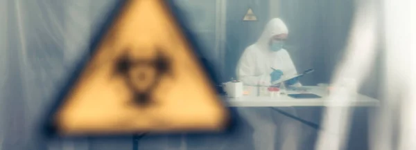 Forskare undersöker i laboratoriet bakom en skyddande gardin — Stockfoto