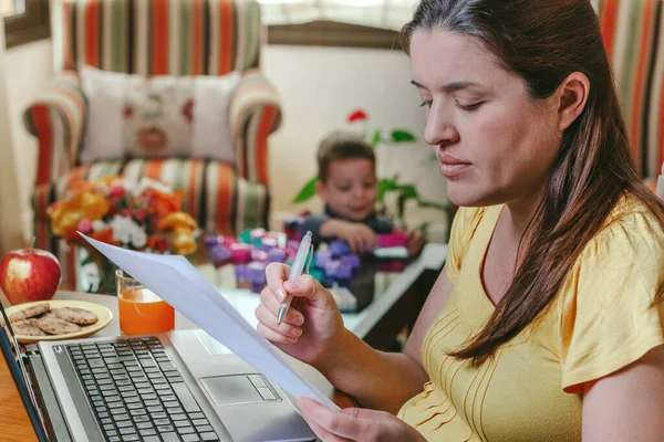Mother working at home while her son plays — Stock Photo, Image