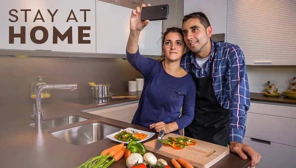 부엌에서 요리하고 스마트폰으로 셀카를 먹는 부부 — 스톡 사진