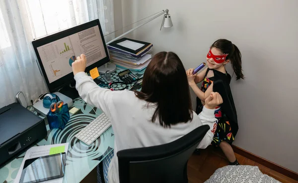 Mujer teletrabajo con hija bailando con ella — Foto de Stock