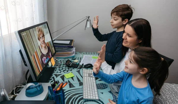 Family waving on video call with grandmother — Stock Photo, Image