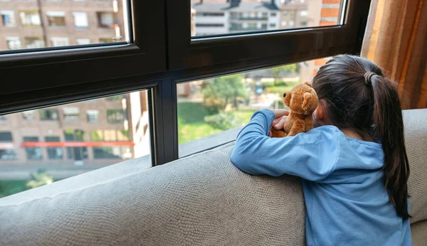 Irriconoscibile ragazza triste guardando fuori dalla finestra — Foto Stock