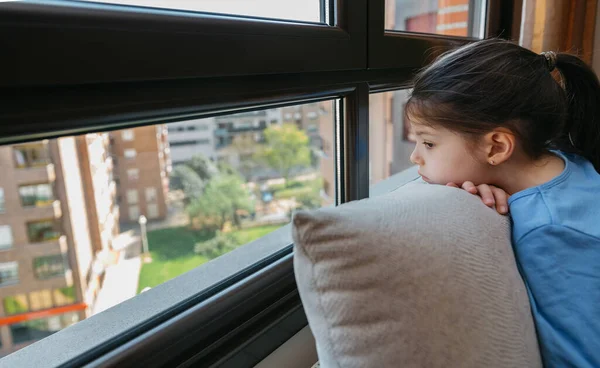 Сумна дівчина дивиться у вікно — стокове фото