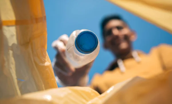 Junger Mann wirft Plastikflaschen in den Müll — Stockfoto