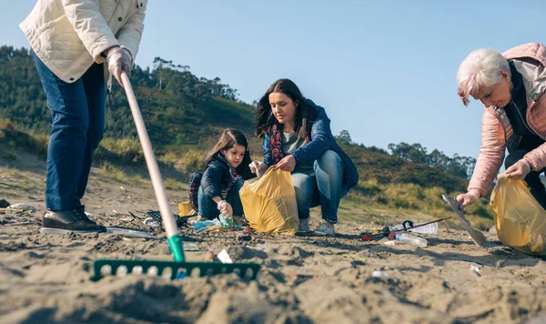 Női önkéntesek takarítják a strandot — Stock Fotó