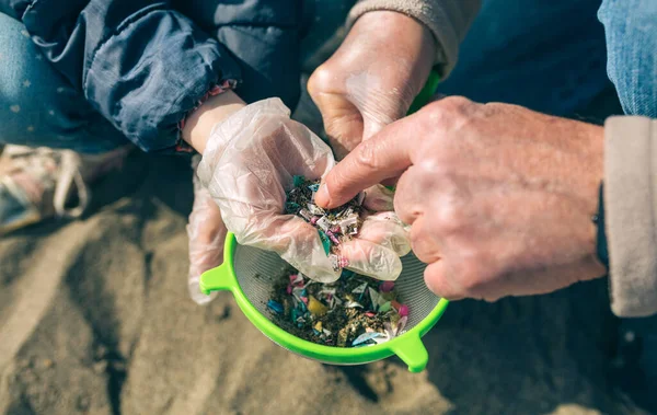 Colander med mikroplast på stranden — Stockfoto
