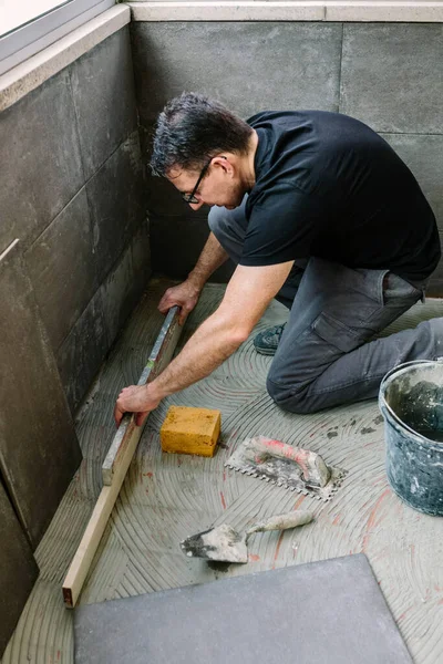 벽돌공을 높이 놓고 바닥을 점검 한다 — 스톡 사진
