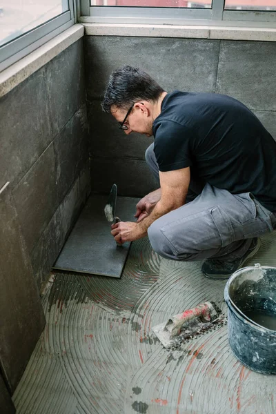 Workman laying tiles on a terrace — Stock Photo, Image