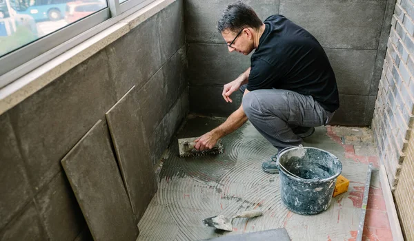 Workman laying tiles on a terrace — Stock Photo, Image