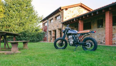 Çimlerin üzerine park edilmiş özel motosiklet.