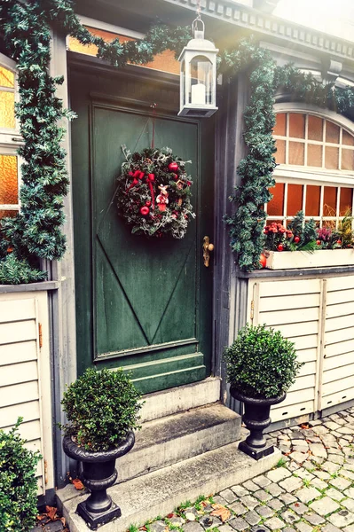 Decoração de casa de Natal com grinalda de abeto na porta — Fotografia de Stock