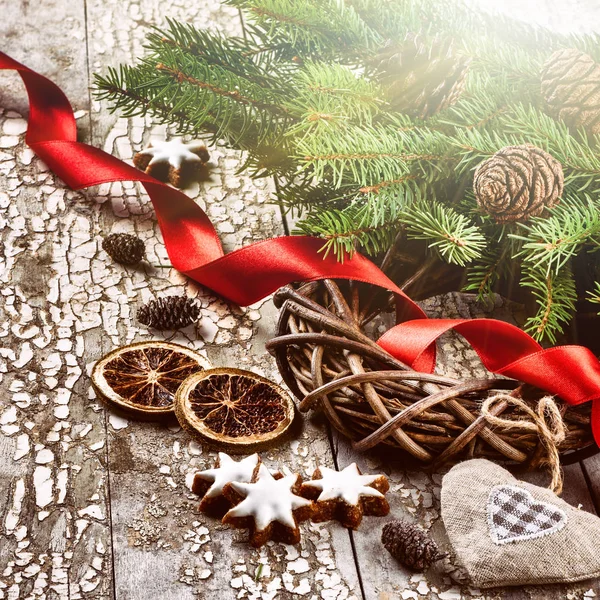 Christmas wreath with red ribbon and fir branches over old wood — Stock Photo, Image