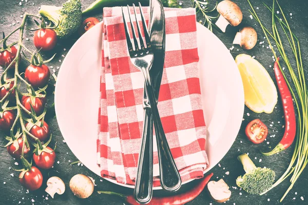 餐桌设置用刀叉放在白盘子和新鲜有机蔬菜上 健康饮食和烹饪理念 — 图库照片