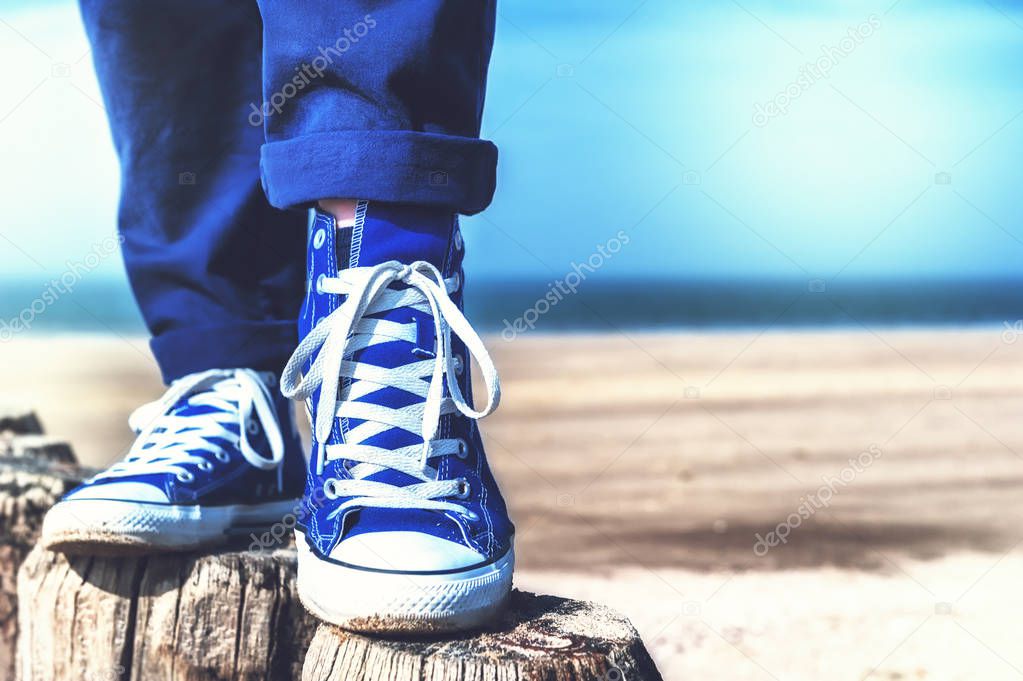 teenager feet standing on wooden poles 
