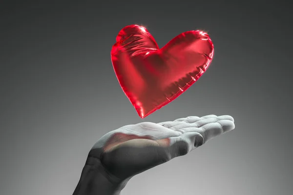 Realistic white human hand holding red heart balloon isolated on dark background. 3d rendering. Proposal. Surprise — Stock Photo, Image