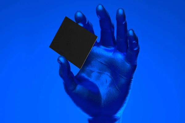 Realistic blue human hand holding blank business card with empty space isolated on blue background. 3d rendering — Stock Photo, Image