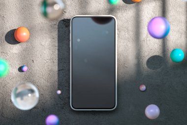 Parlak ve mat cam topların yanında beton zeminde boş ekranlı cep telefonu. 3D görüntüleme. Ön görünüm