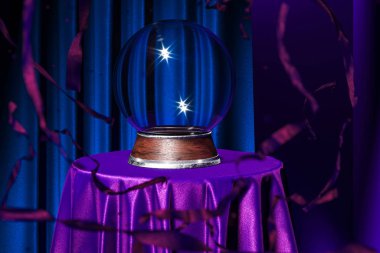 Magic Ball Fortune Teller on Table Covered Violet Cloth Near Red Serpentine And Blue Curtains, 3d rendering., Copy Space