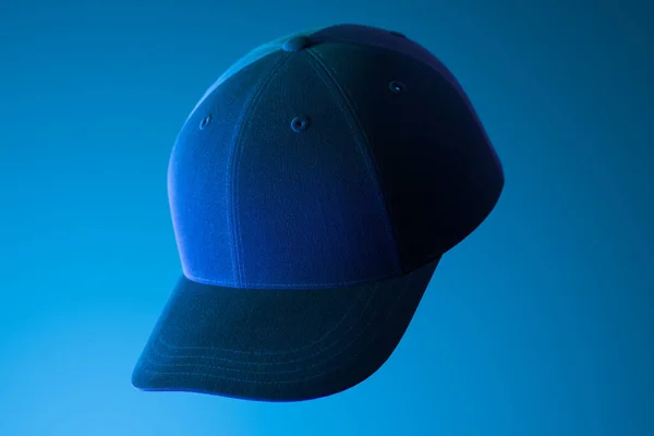 Темна реалістична порожня шапка на синьому фоні, освітлена неоновим світлом. 3D рендерингу . — стокове фото