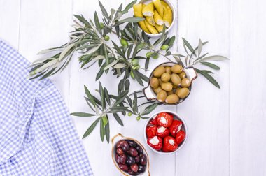 Geleneksel mezeler, Yunan mutfağından zeytinler. Beyaz ahşap arka plan. Yukarıdan bak. Taze zeytin dalları. Boşluğu kopyala.