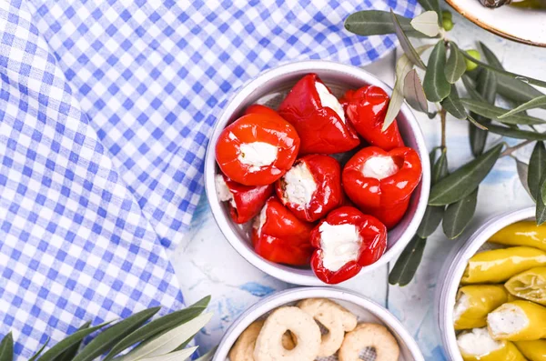 Traditionelle Vorspeisen, grüne und rote Oliven aus der griechischen Küche. Frische Olivenzweige. Kopierraum. Oben. Blau karierte Tischdecke. — Stockfoto