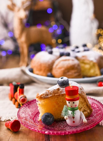 Weihnachtskuchen mit Beeren und Puderzucker auf einem hölzernen Hintergrund. Stück Kuchen. Traditionelles Gebäck in Italien. Bokeh im Hintergrund — Stockfoto