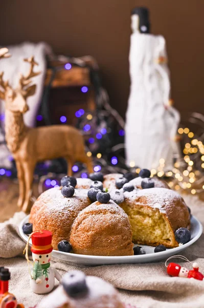 Weihnachtskuchen mit Beeren und Puderzucker auf einem hölzernen Hintergrund. Stück Kuchen. Traditionelles Gebäck in Italien. Bokeh im Hintergrund — Stockfoto