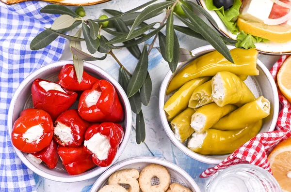 Traditionelle Vorspeisen, grüne und rote Oliven aus der griechischen Küche. Frische Olivenzweige. Kopierraum. Oben. Blau karierte Tischdecke. — Stockfoto