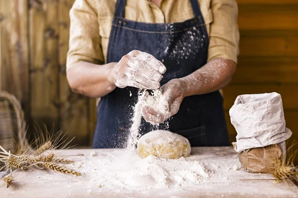 Las manos de las mujeres, la harina y la dólar.Levitación en un marco de masa y flor.Una mujer en un delantal está preparando la masa para hornear en casa. Foto de estilo rústico. Mesa de madera, espigas de trigo y harina. Foto emocional . —  Fotos de Stock