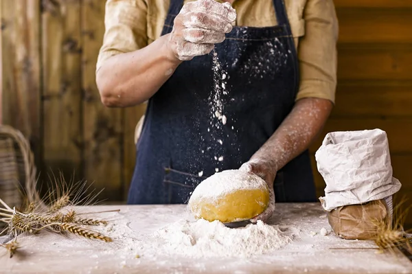 Las manos de las mujeres, la harina y la dólar.Levitación en un marco de masa y flor.Una mujer en un delantal está preparando la masa para hornear en casa. Foto de estilo rústico. Mesa de madera, espigas de trigo y harina. Foto emocional . —  Fotos de Stock