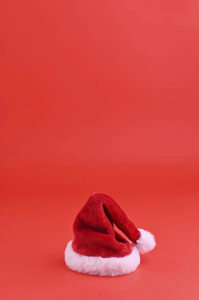 Fundo vermelho de Natal e chapéu de Papai Noel. Cartão de férias com espaço de cópia — Fotografia de Stock