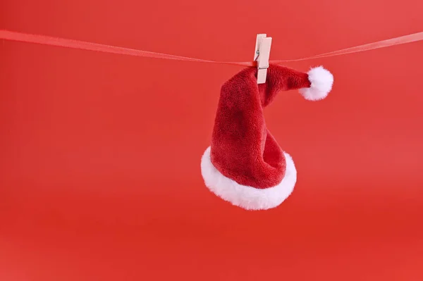 Fundo vermelho de Natal e chapéu de Papai Noel. Cartão de férias com espaço de cópia — Fotografia de Stock