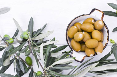 Beyaz ahşap arka planda böğürtlenli taze zeytin dalı. İtalya 'nın geleneksel bitkisi. Metin için boş alan. Düz yatıyordu.