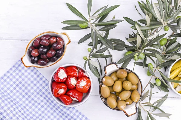 stock image Traditional appetizers, olives from Greek cuisine. White wood background. View from above. Fresh branches of olives. Copy space.