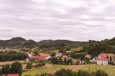 Yeşil tepeler ve Slovenya 'da eski bir köy. Avrupa 'da seyahat ve turizm. Doğa, gökyüzü ve üzüm bağları.
